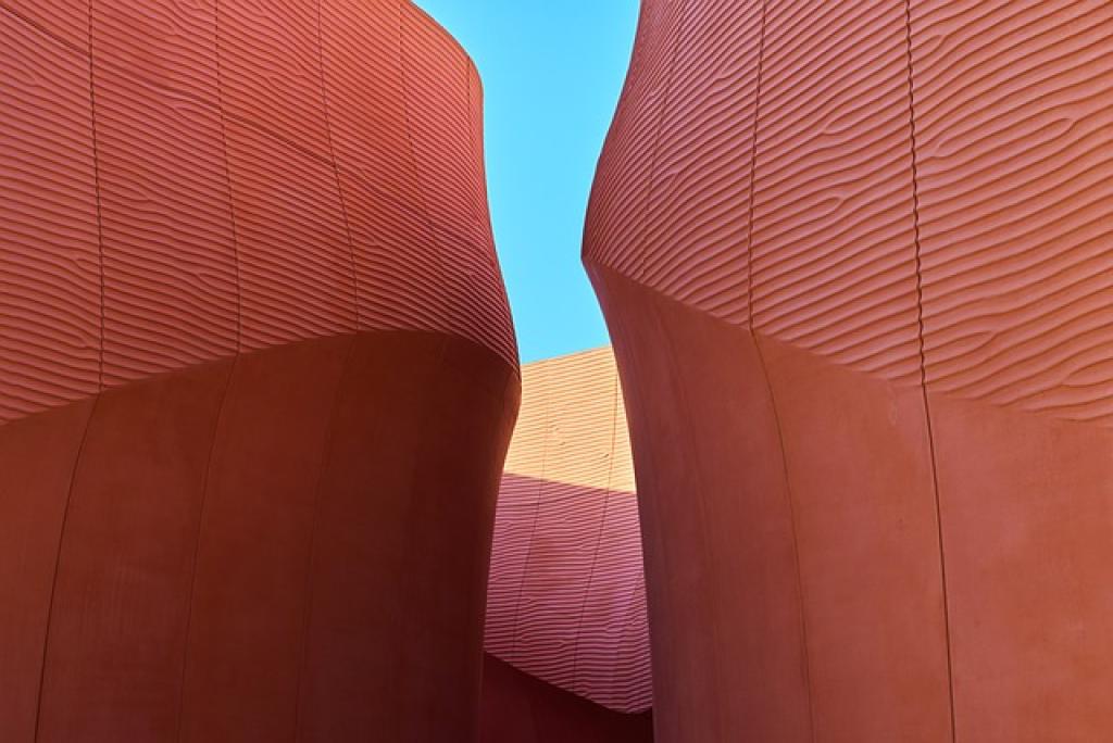 Curved red walls against blue sky