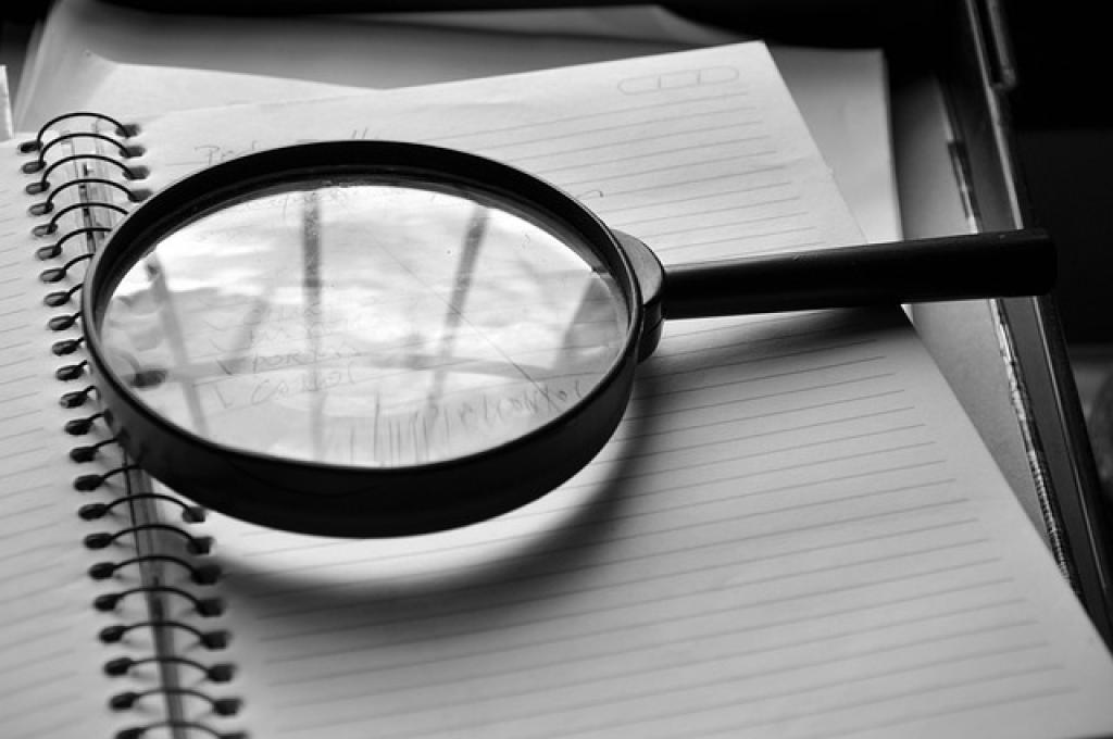 Magnifying glass on blank notebook
