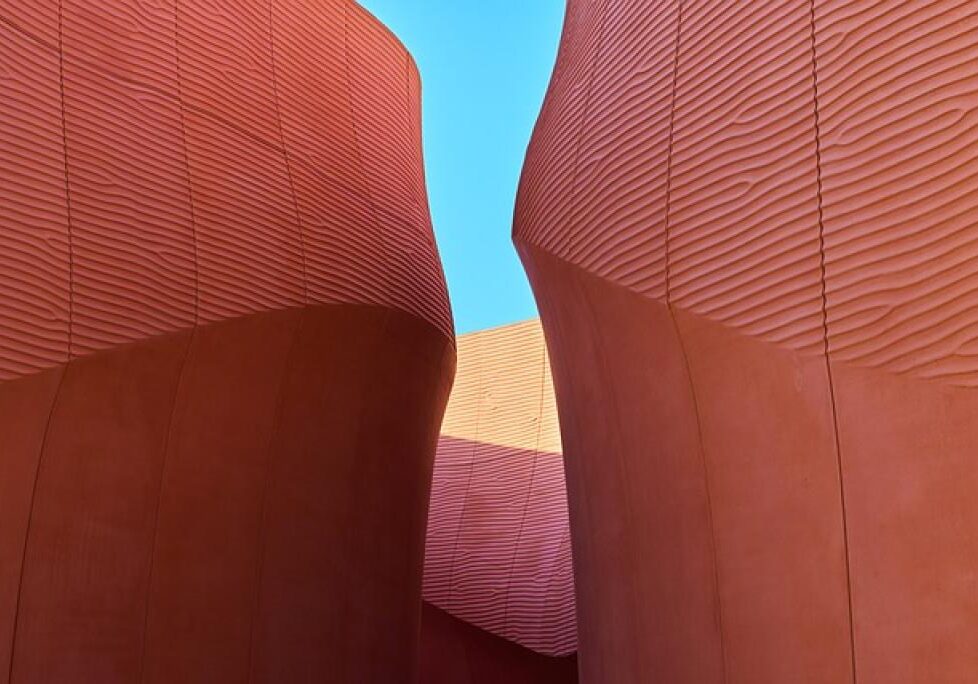 Curved red walls against blue sky