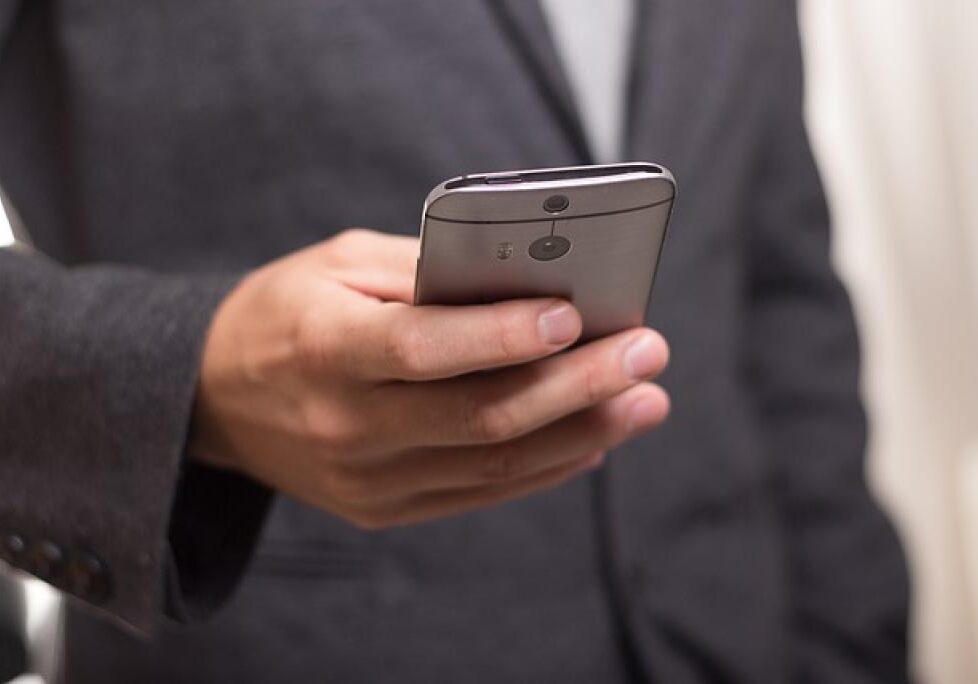 Man holding smartphone in suit