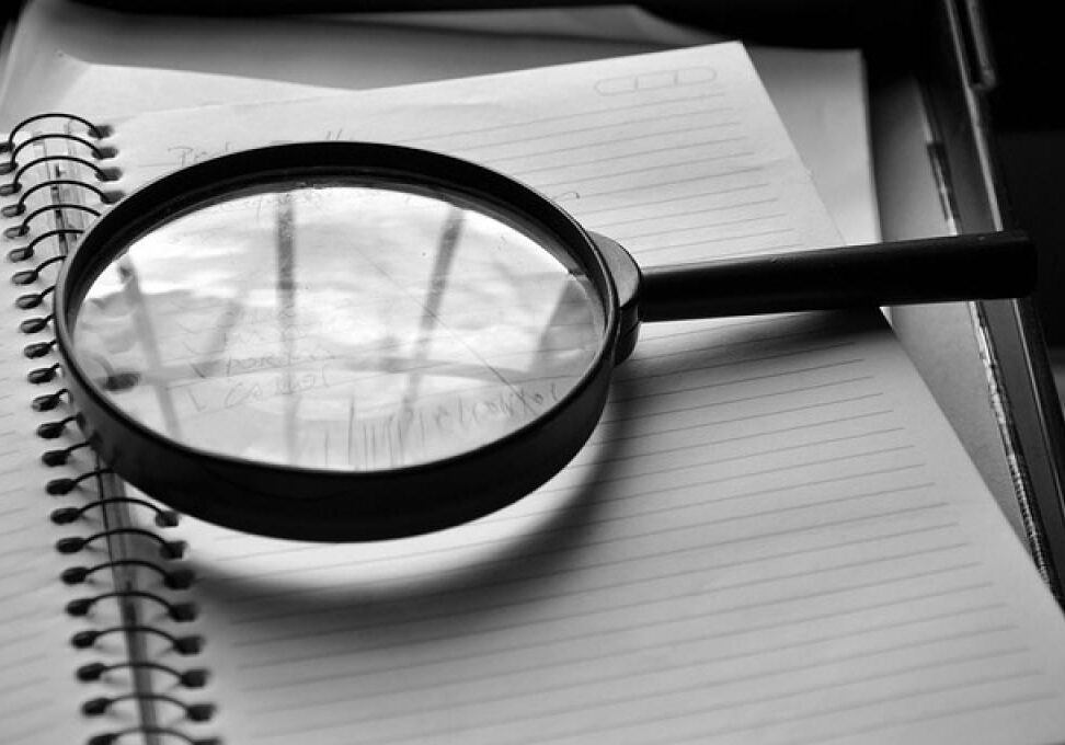Magnifying glass on blank notebook
