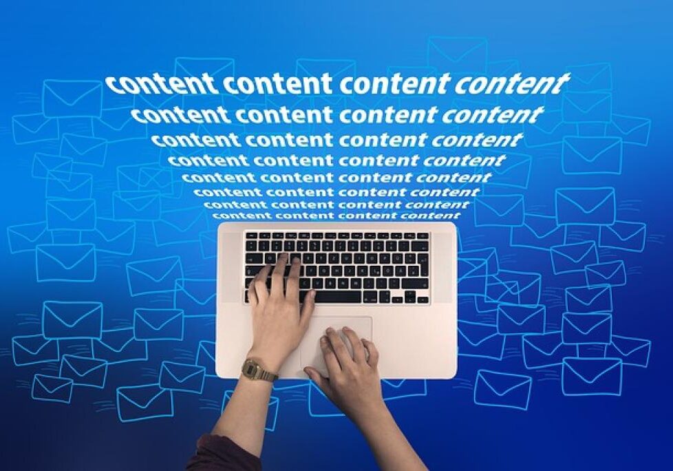 Hands typing on laptop with content