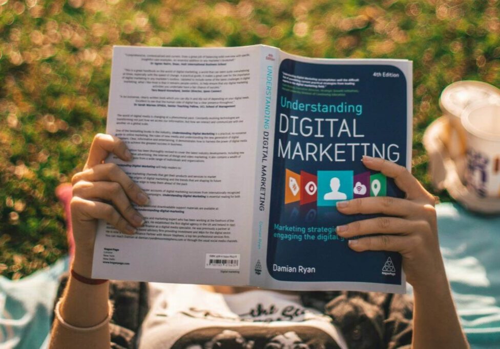 Girl reading a book about Digital Marketing